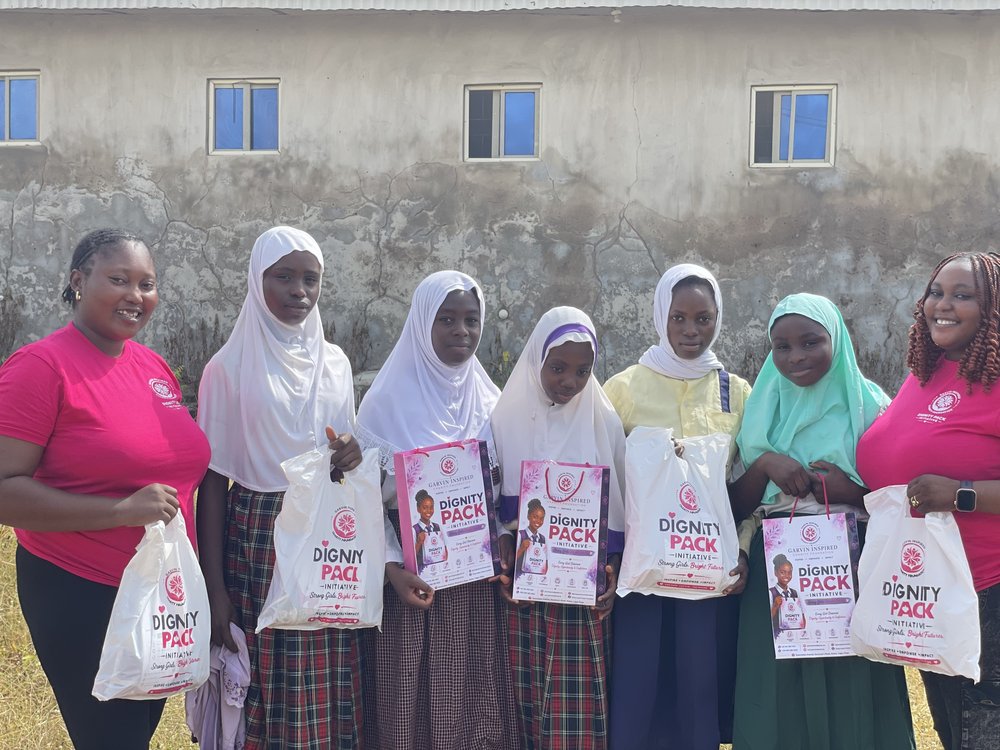 Garvin Inspired Charity Foundation Dignity Pack Initiative volunteers with schoolgirls holding donated packs